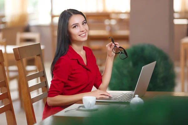 Giovane donna d'affari utilizza il computer portatile in caffè — Foto Stock