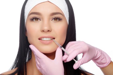 Genç kadın enjeksiyon dudaklarını içinde alır.