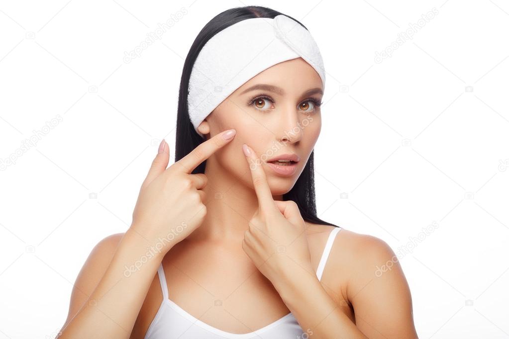 Young woman squeezing her pimple