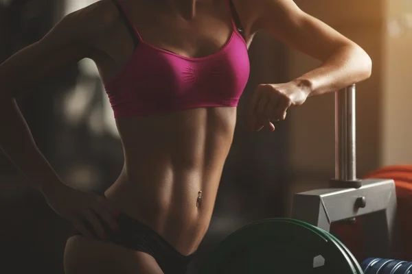 Жестокая атлетичная женщина накачивает мышцы гантелями — стоковое фото