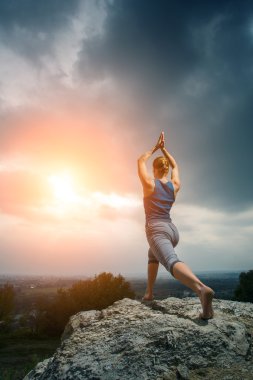 Batan güneşin karşı yoga yaparken kadın