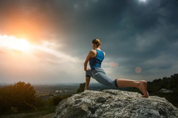 Femme faisant du yoga contre le soleil couchant — Photo
