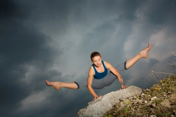 Frau macht Yoga gegen die untergehende Sonne — Stockfoto