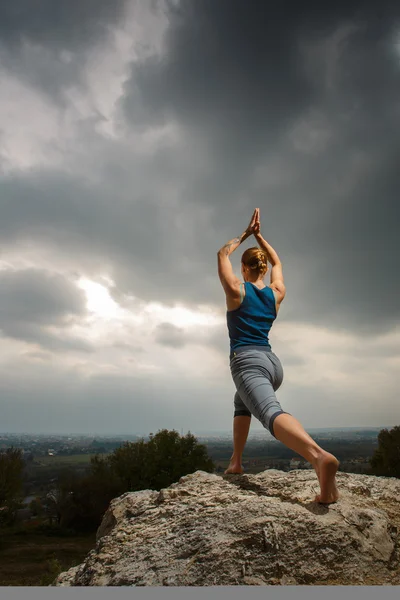 Mujer haciendo yoga contra el sol poniente — Foto de Stock