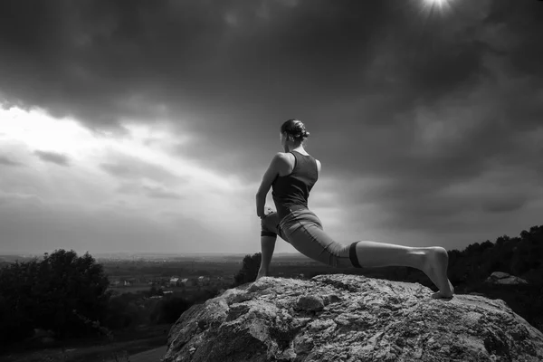 Woman doing yoga against the setting sun — Stock Photo, Image