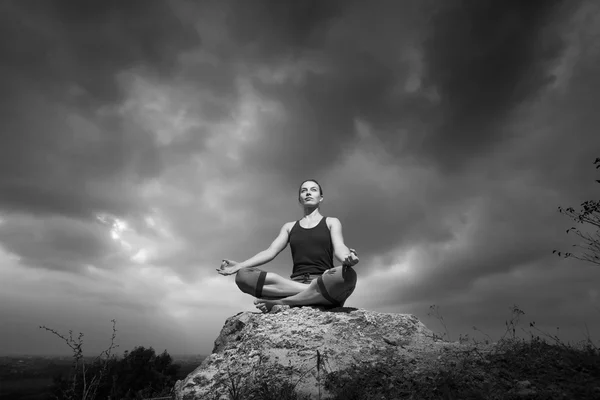 Mulher fazendo ioga contra o pôr do sol — Fotografia de Stock