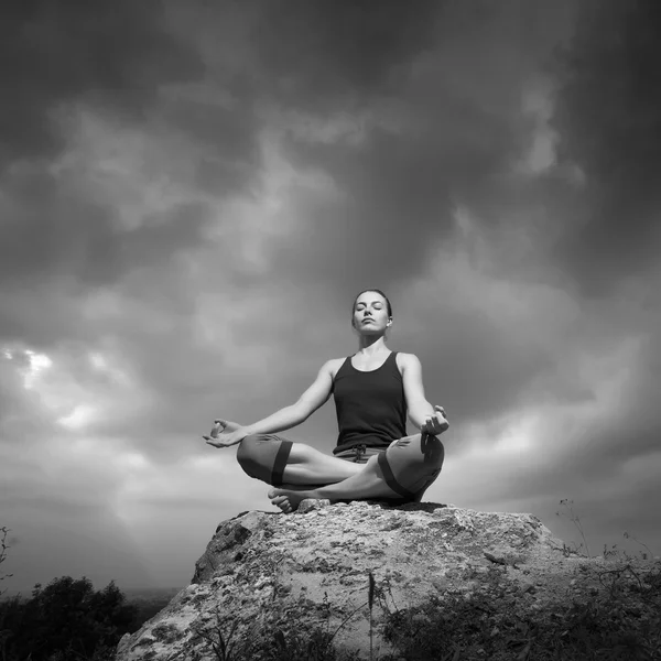 Frau macht Yoga gegen die untergehende Sonne — Stockfoto