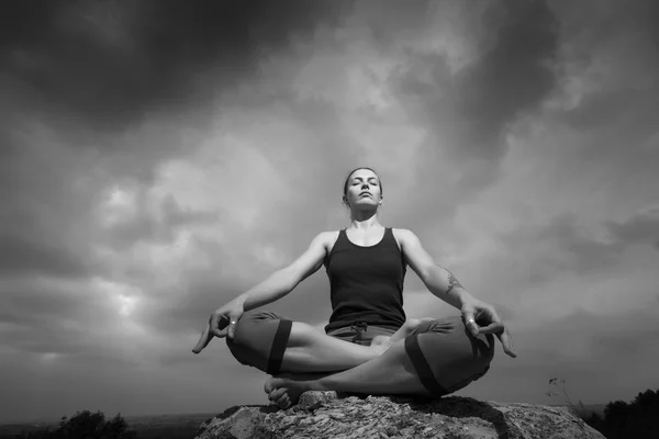 Vrouw doen yoga tegen de ondergaande zon — Stockfoto