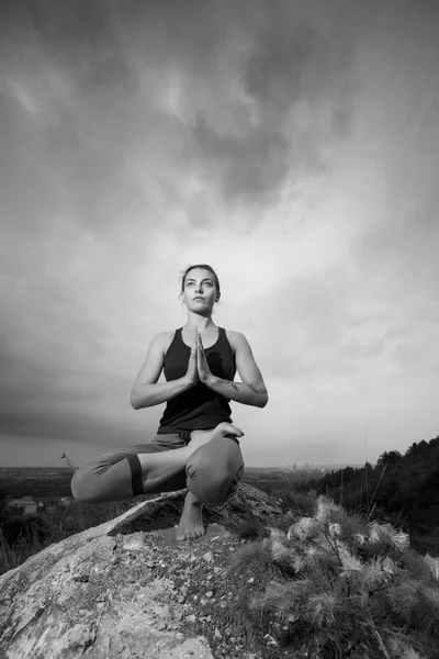 Mulher fazendo ioga contra o pôr do sol — Fotografia de Stock