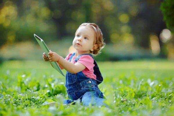 Child playing with tablet outdoors — Stock Photo, Image