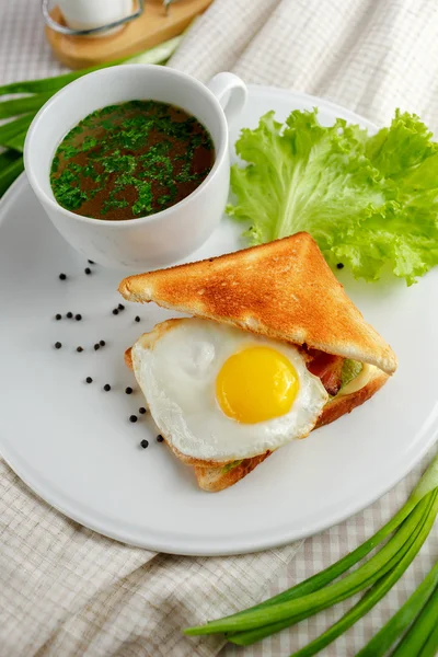 Sandwich con huevo frito y taza de sopa — Foto de Stock