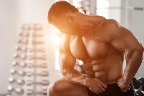 Brutal bodybuilder preparing to workout with dumbbells — Stock Photo, Image