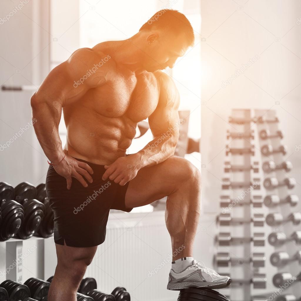 Brutal bodybuilder preparing to workout with dumbbells