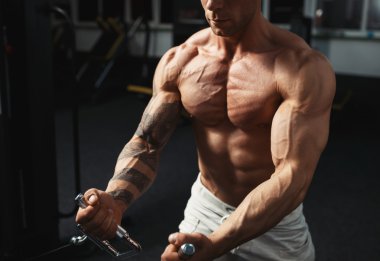 spor salonunda egzersiz yaparak güçlü vücut geliştirmeci