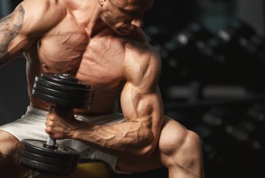 strong bodybuilder doing exercise with dumbbell