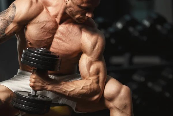 Strong bodybuilder doing exercise with dumbbell — Stock Photo, Image