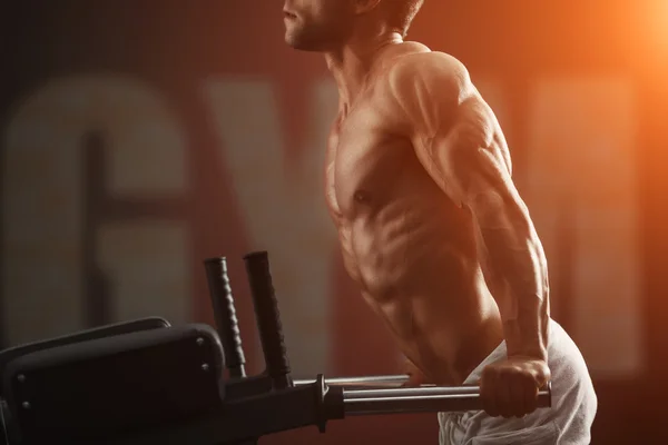 Strong bodybuilder doing exercise on bars — Stock Photo, Image