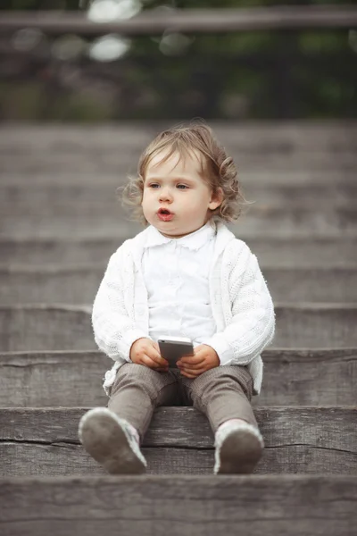 Liten flicka spelar med mobiltelefon — Stockfoto