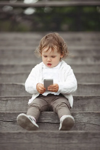 Little girl playing with mobile phone — Stock Photo, Image