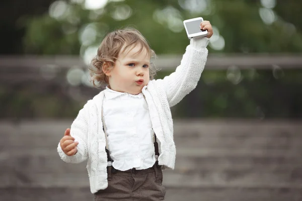 Liten flicka spelar med mobiltelefon — Stockfoto