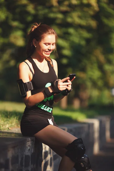 Mädchen sitzt und hält Handy. — Stockfoto