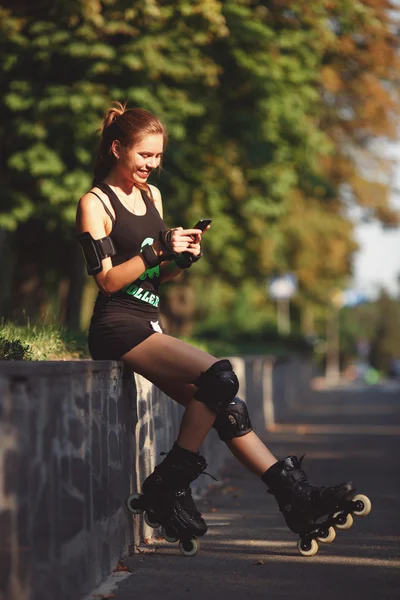 Dívka sedí a drží mobilní telefon. — Stock fotografie