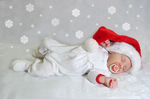 Noel Baba kırmızı şapkalı Noel yeni doğan bebek uyuyor. Fotoğraf takvim için kartı — Stok fotoğraf