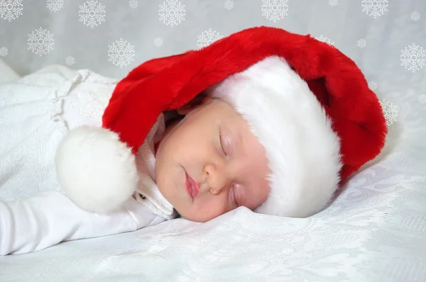 Noel Baba kırmızı şapkalı Noel yeni doğan bebek uyuyor. Fotoğraf takvim için kartı — Stok fotoğraf