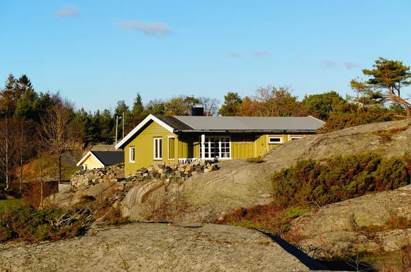 Green cottage hidden between the rocks — Stock Photo, Image