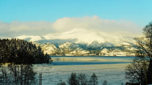 Snötäckta berg och frusen sjö — Stockfoto