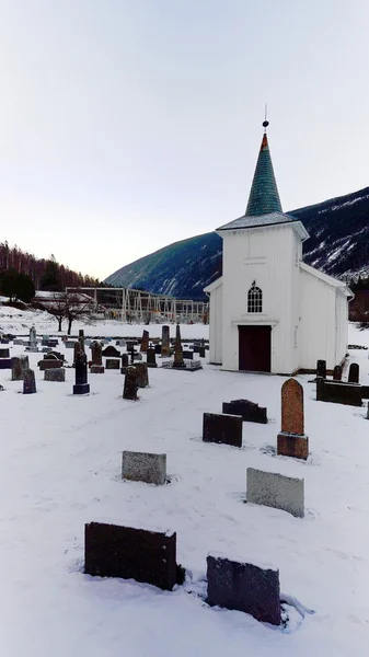 Церковное кладбище и деревянная церковь покрыты снегом — стоковое фото