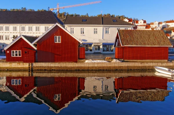 Red old buildings on the mirror image in the water — Stock Photo, Image