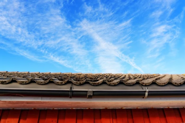 Toit avec des tuiles grises sur fond de ciel bleu — Photo