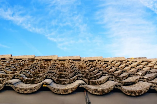 Techo con azulejos grises en las pestañas en el fondo del cielo azul — Foto de Stock