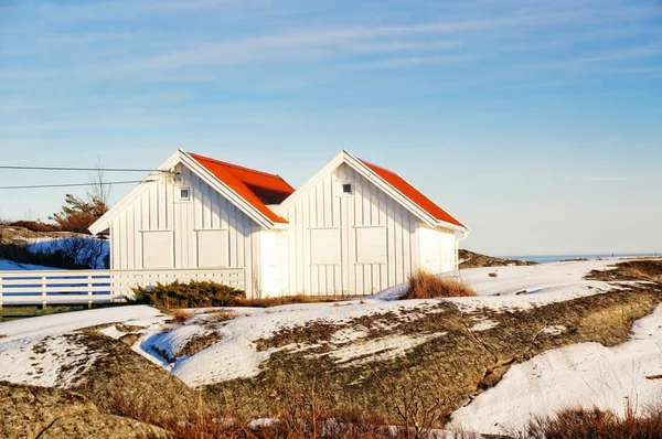 White wooden cottage with red roofs on coast — Stock Photo, Image