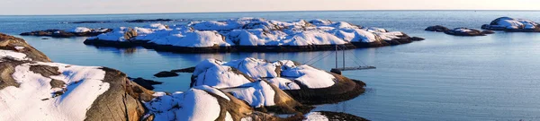 北の海の雪に覆われた岩の多い海岸のパノラマ ストックフォト
