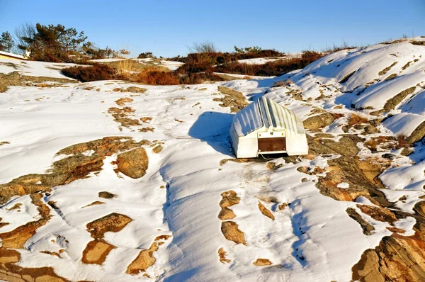 Barco blanco invertido en la costa rocosa de invierno —  Fotos de Stock