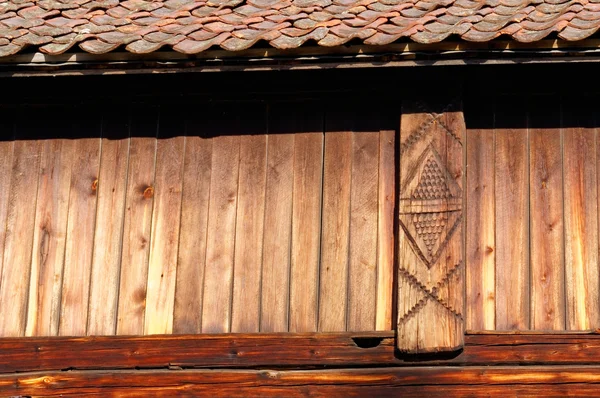 Antiguo muro corredizo rosa debajo del techo de estaño: fotografía de