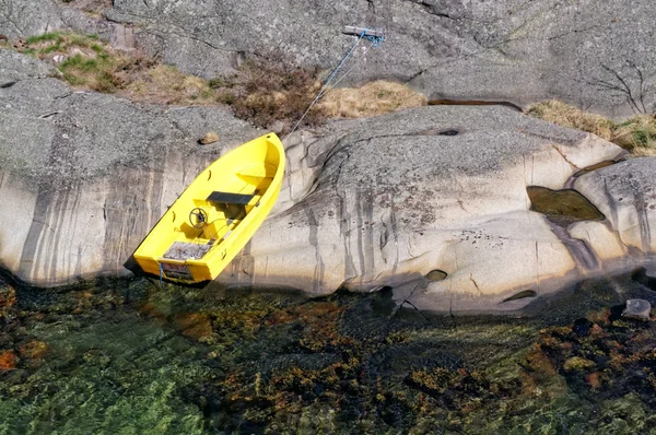 Pequeno barco amarelo amarrado a uma rocha — Fotografia de Stock