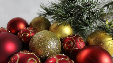 Noel süslemesi: Ladin dallarının yanında bir sürü kırmızı ve altın toplar var..