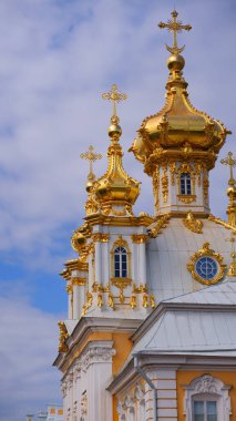 Güneşli bir günde açık mavi gökyüzüne karşı altın kubbeleri olan kilise. Mavi gökyüzüne karşı kilisenin kubbesinde Ortodoks haçı. St. Petersburg, Petrodvorets.