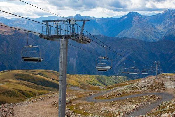 Cable car with open seats in the mountains in summer. Ski lift in the Caucasus in Georgia. View from the top of the mountain.