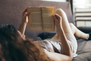 Genç kız kitap okuyor. 