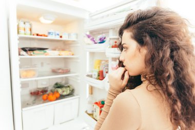 Açık buzdolabına duran kadın