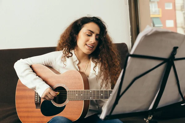 Молодая девушка с длинными волосами играет на гитаре — стоковое фото