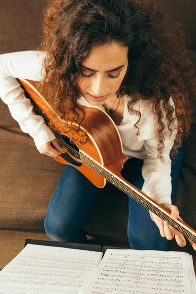 Молода дівчина з довгим волоссям грає на гітарі — стокове фото