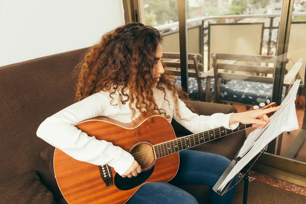 Młoda dziewczyna z długimi włosami gra na gitarze — Zdjęcie stockowe
