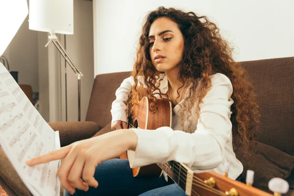Молода дівчина з довгим волоссям грає на гітарі — стокове фото