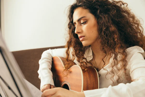 Chica joven con el pelo largo tocando la guitarra — Foto de Stock