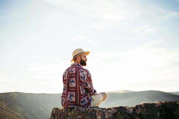 Hombre sentado en una roca mirando — Foto de Stock